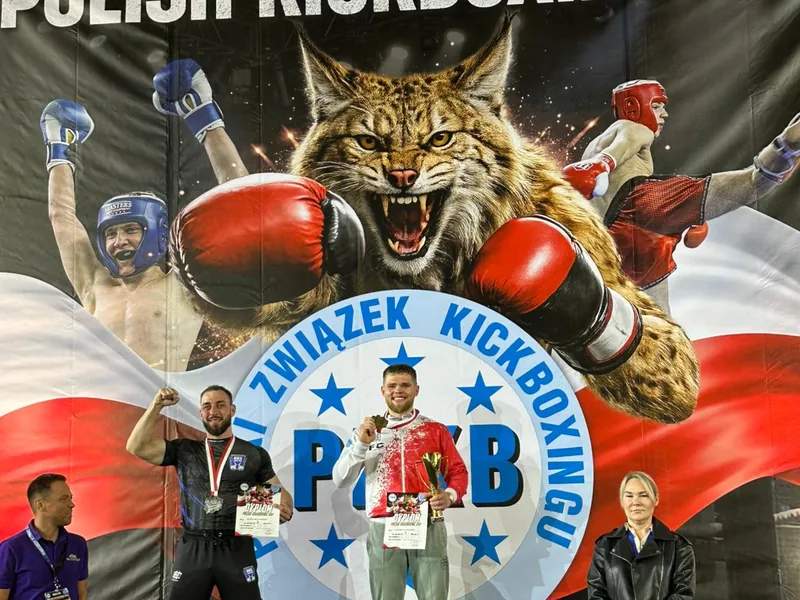 Janek Matyjaszczyk na podium pod banerem Polskiego Związku Kickboxingu